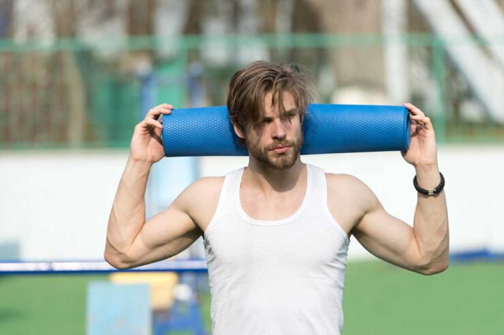 Man athlete with blue foam rollers
