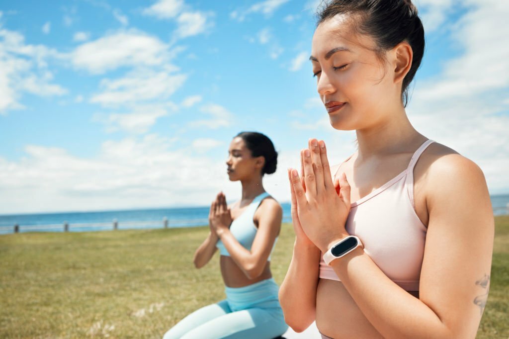 Fitness, yoga and woman in spiritual wellness, exercise and training workout for mental wellbeing in nature. Women in meditation pose on grass in calm, peace and zen for healthy mind, body and spirit